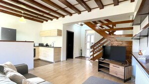 A modern living room with a wooden ceiling, a TV, and a sofa. - Mountain Escape Chalet - BBQ and Mountain View (Bușteni)
