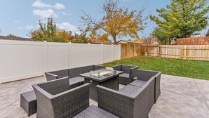 Een terras met een vierkante tafel en vier stoelen.