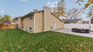 A two-story house with a covered patio area. - Sandy Ski Cottage | Central | Free Massage* | Patio (Sandy)