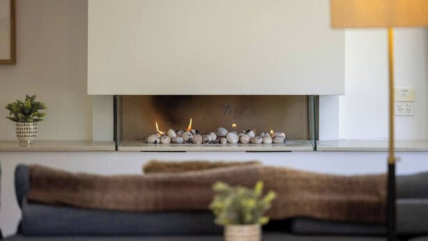 Un salon moderne avec une cheminée, un canapé et une lampe.