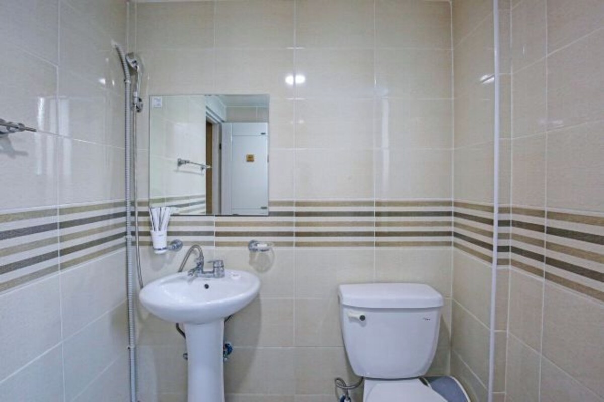 Une salle de bain avec un lavabo, des toilettes et un miroir.
