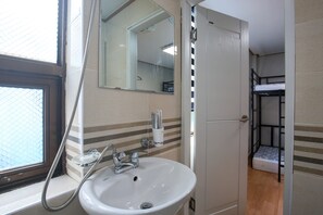 Chambre de base avec lits jumeaux | Salle de bain | Douche, séchoir à cheveux, serviettes fournies, savon