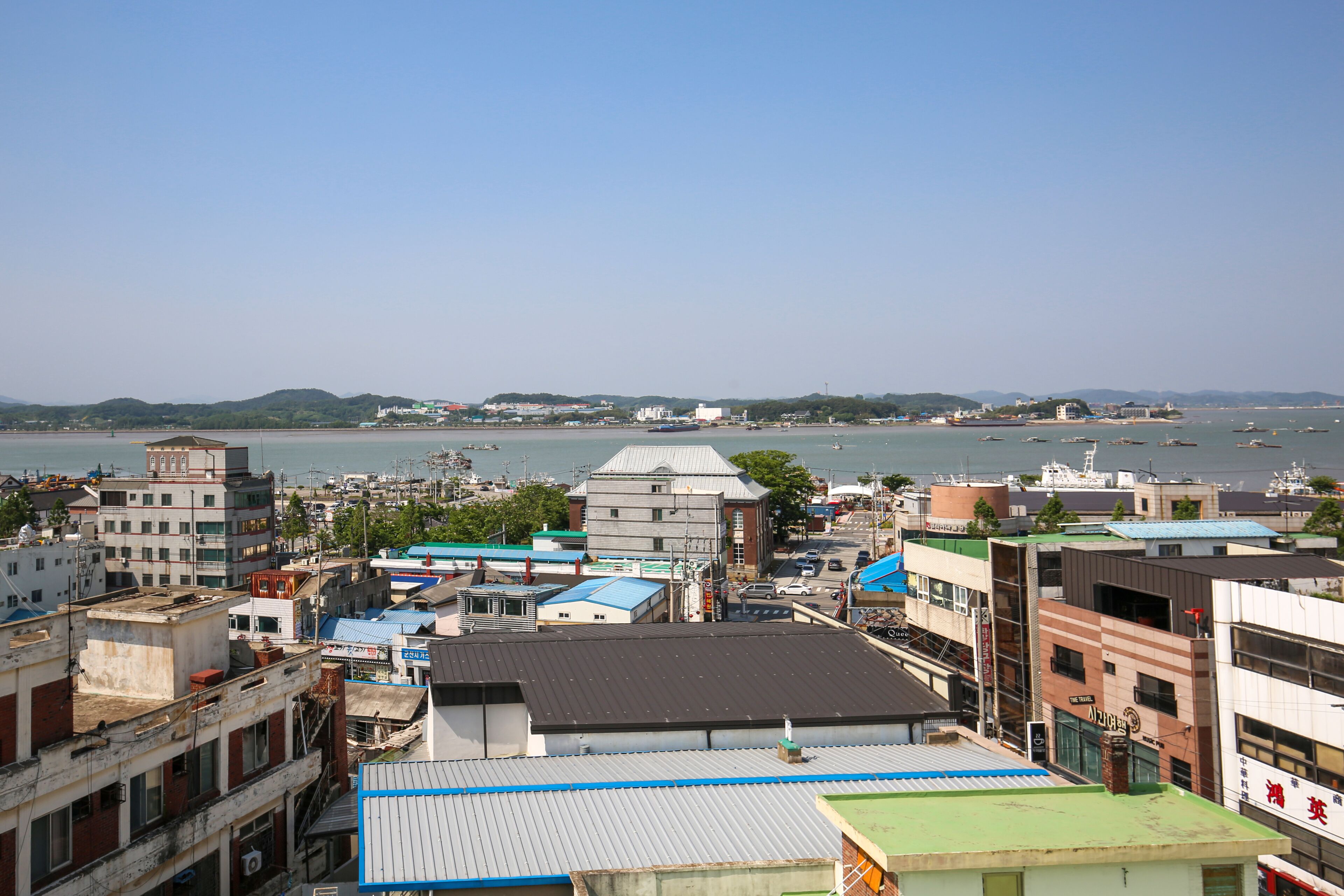 A coastal cityscape with buildings and a marina.