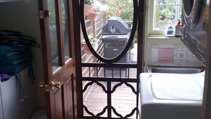 Eine Küche mit großem Fenster, einer Tür mit dekorativem Metallgitter und einer Waschmaschine.