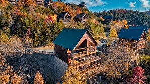 Eine Lodge mit Holzfassade, mehreren Balkonen und einem schönen Blick auf einen bewaldeten Hang.