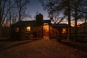 Cozy cabin-style building with a traditional design, featuring a wooden door and a small porch area for relaxation.