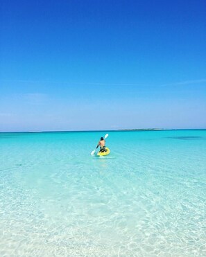 A person on a yellow raft in clear turquoise water.