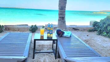 Playa privada, playa de arena blanca, camastros y sombrillas