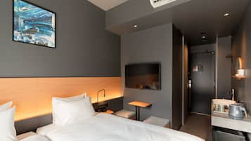 A modern hotel room with a large bed, a desk, a flat-screen TV, and a painting on the wall.