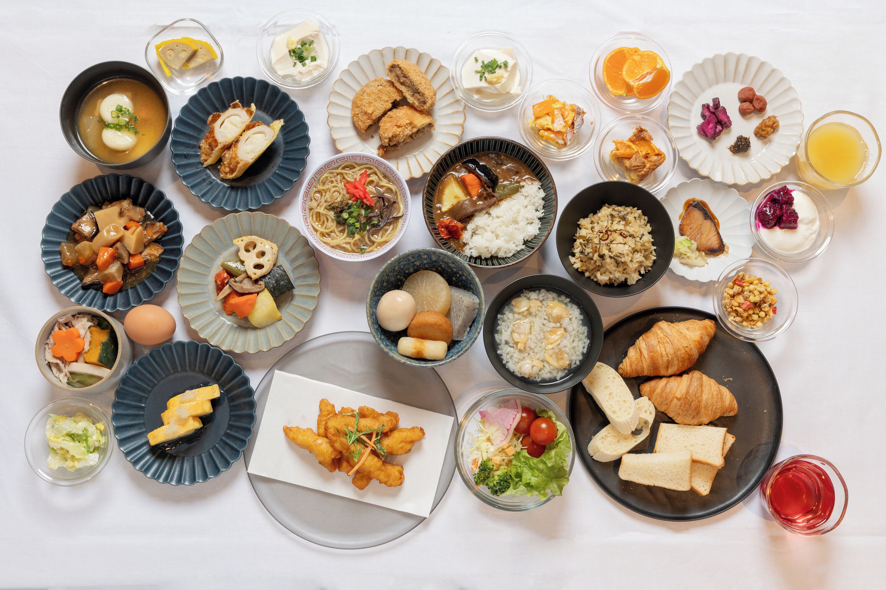 Una variedad de platos que incluyen sushi, arroz y sopa, dispuestos sobre una mesa.
