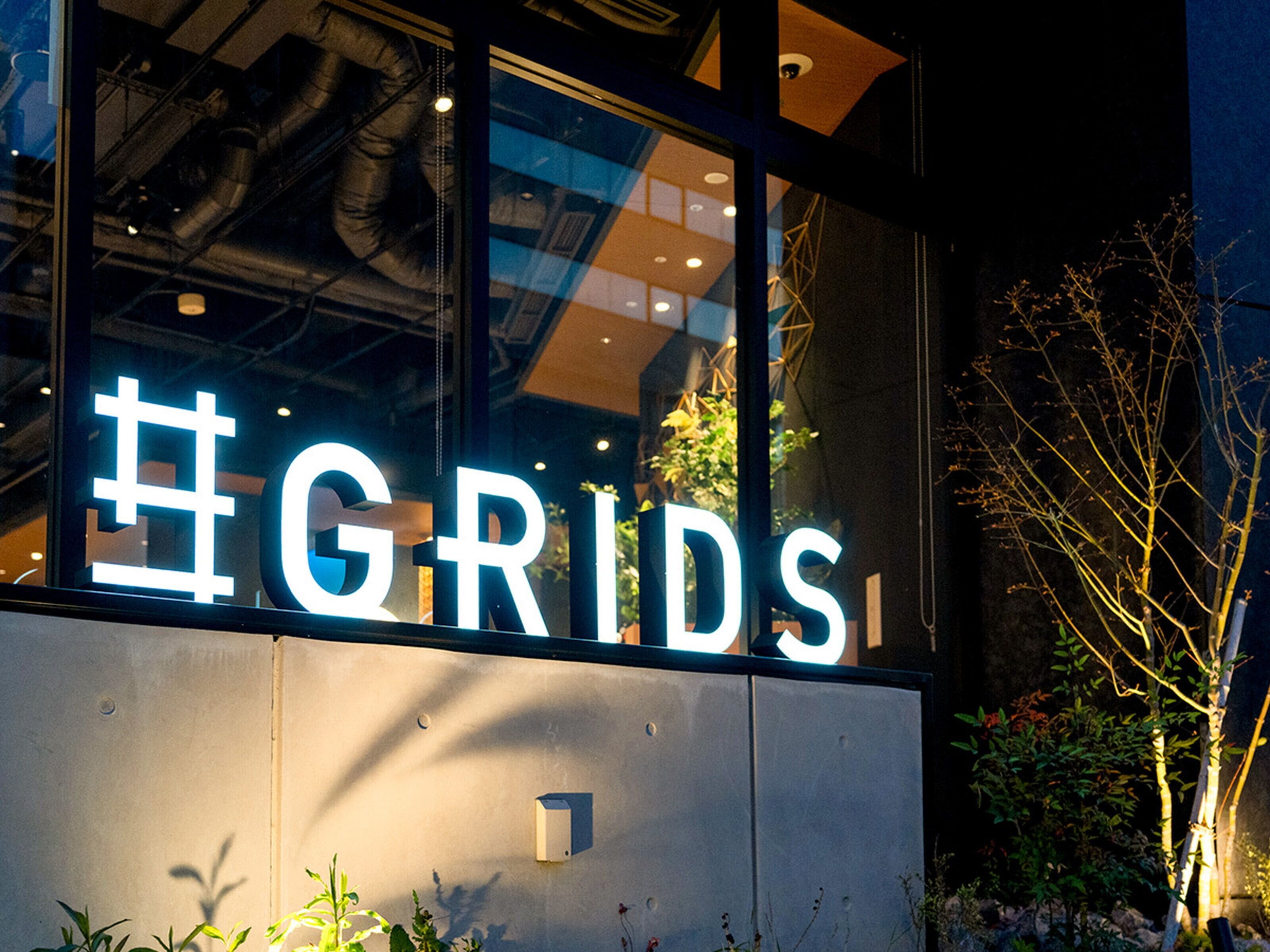 A building with a large illuminated sign reading "#GRIDS".