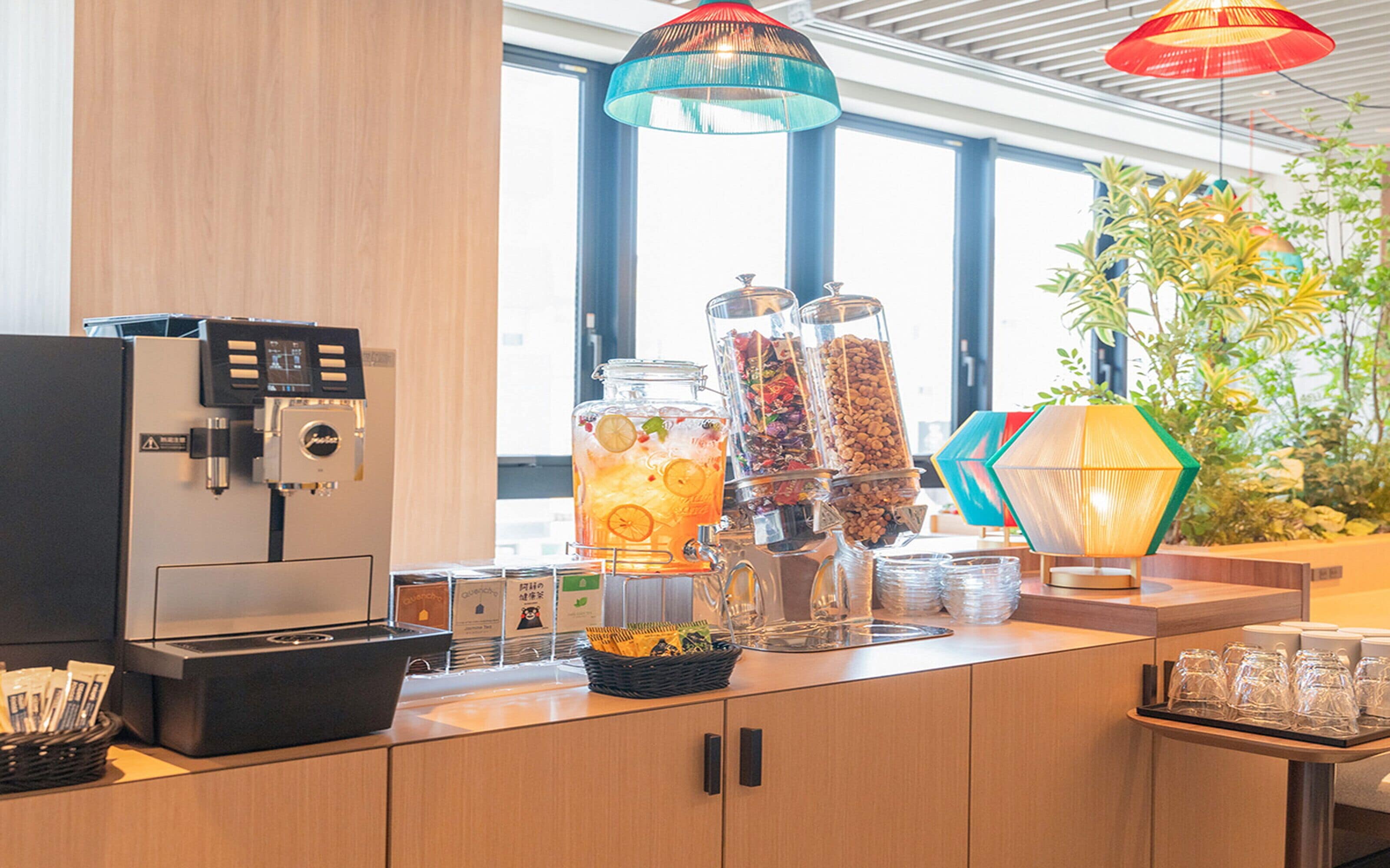 A coffee station with a coffee machine, beverage dispensers, and a variety of snacks.