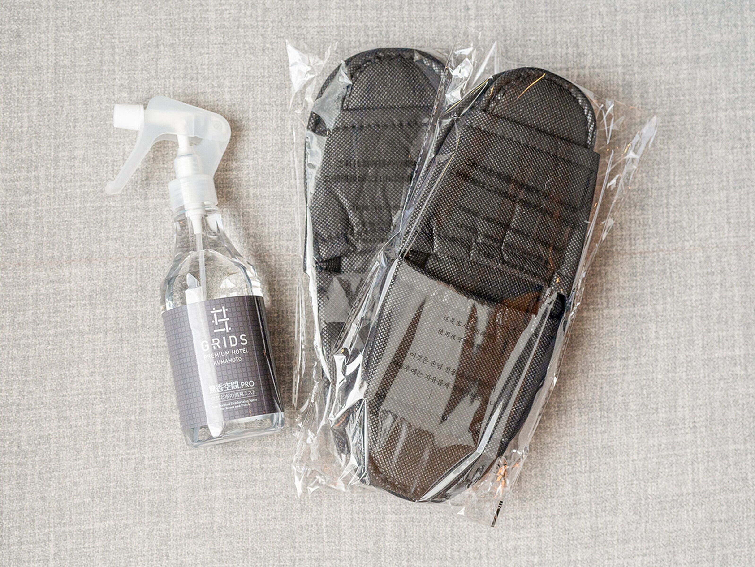 Schwarze Hausschuhe und eine Flasche Reinigungsspray der Marke hotel-pro.