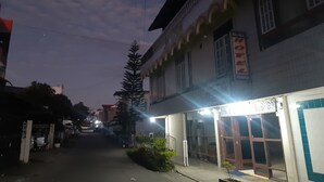 A hotel entrance with a signboard, a gated driveway, and a pathway leading to the building. - Hotel O Triarga (Takengon)