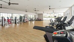 A spacious gym with various exercise equipment, ceiling fans, and large windows. - Alanis Sepang at Klia-Klia2 (Sepang)