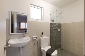 A modern bathroom with a white sink, a toilet, a glass shower enclosure, and a window above the sink. - Alanis Sepang at Klia-Klia2 (Sepang)