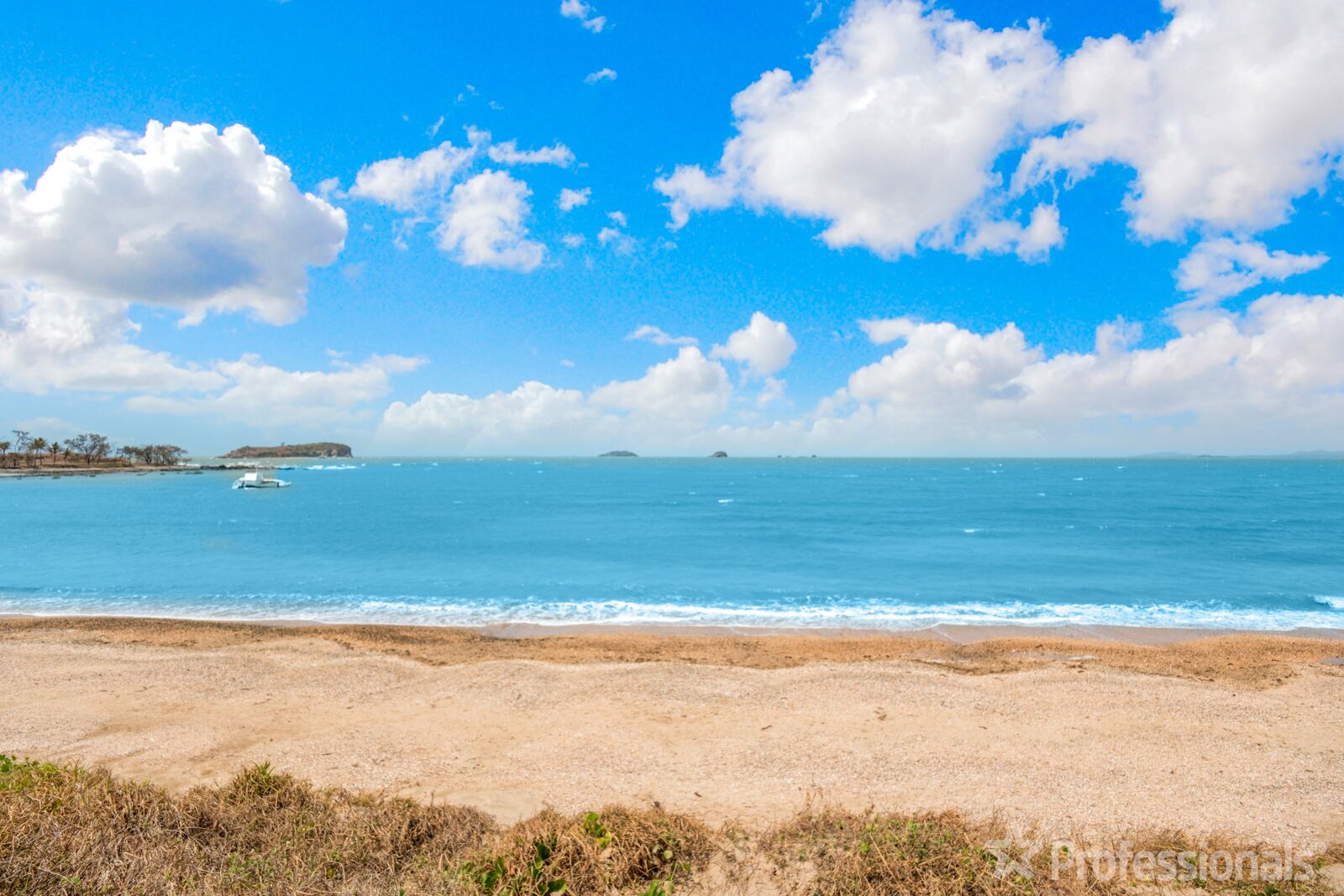 A beach with a clear sky and calm sea.