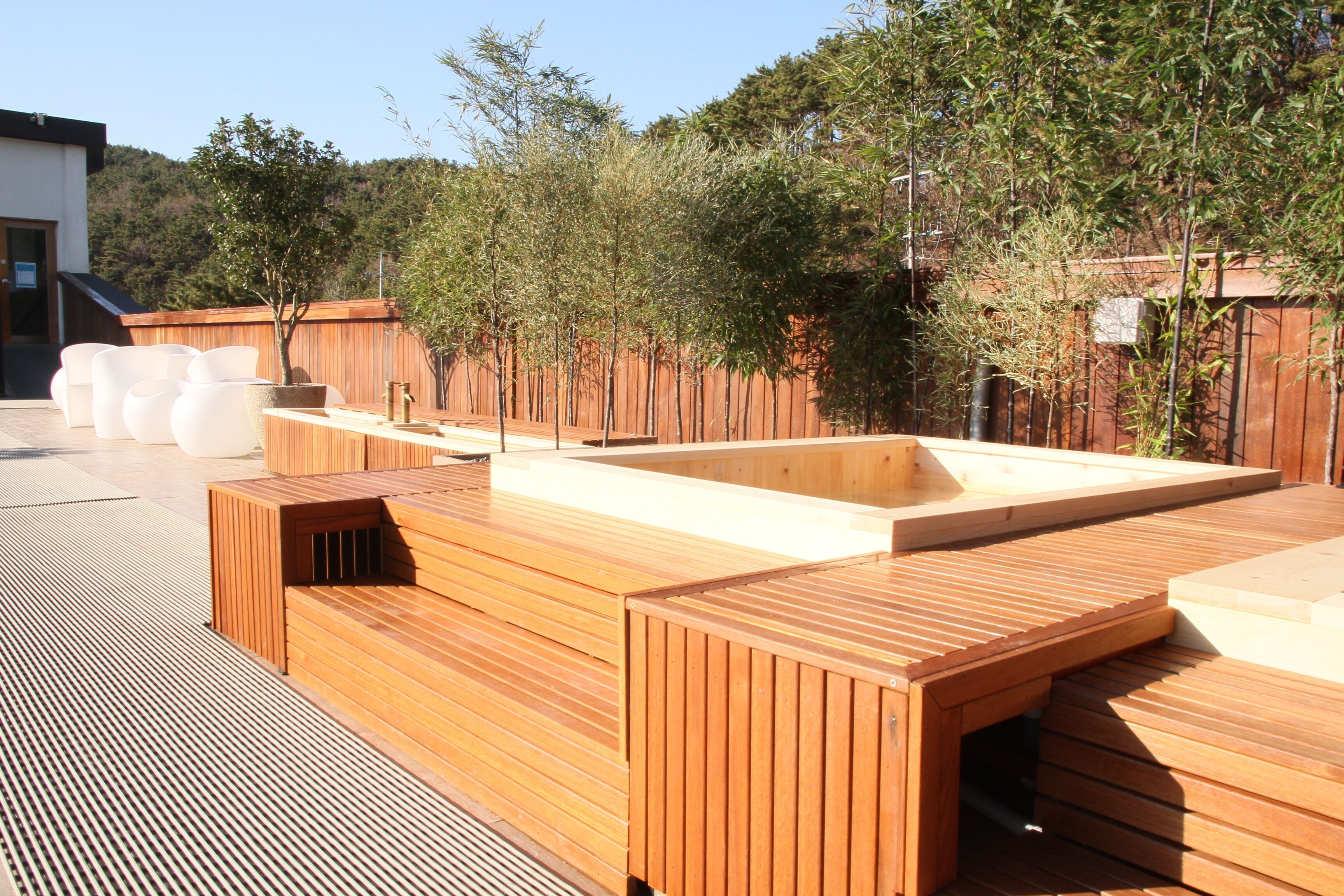 A wooden deck with built-in seating and a rectangular planter.