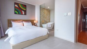 Una camera d'albergo moderna con un letto grande, un bagno con vasca e doccia.