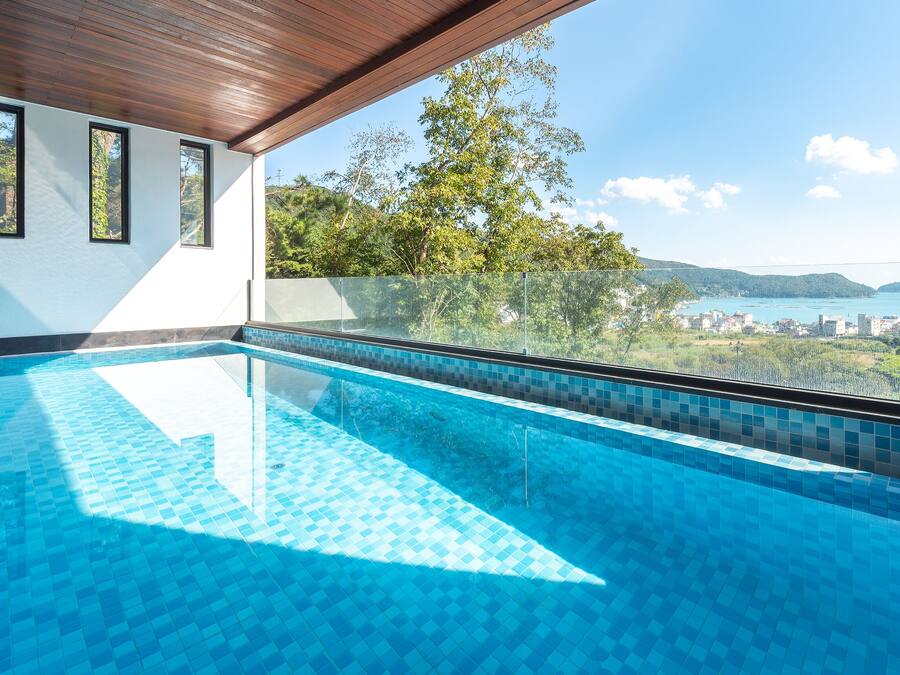 Una piscina con vistas despejadas a un paisaje urbano y colinas al fondo.