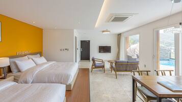 A hotel room with two beds, a dining table, and a TV.