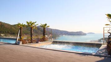 Une piscine avec vue sur la mer et les montagnes.