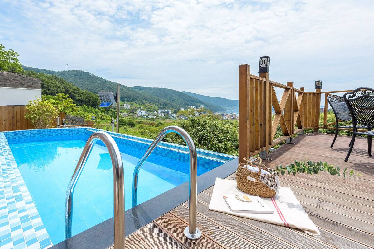 A pool with a view of a town and mountains.
