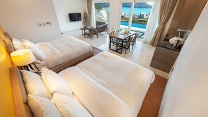 A hotel room with two beds, a dining area, and a view of the sea. - Friemily Pool Villa & Hotel (Geoje)