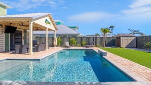 A backyard with a swimming pool, patio furniture, and a covered seating area. - Shellfish Cottage offers gulf views, pool, hot tub, outdoor kitchen! Steps to beach! (Port Saint Joe)