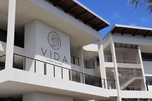 A multi-story building with a prominent sign reading "VIDA" and "EAYMAN ISLANDS" on the facade. - VIDA Cayman (West Bay)