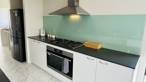 Une cuisine moderne avec un réfrigérateur noir, une cuisinière et un lave-vaisselle.