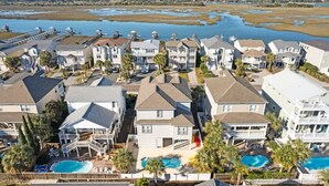 A residential area with houses, a swimming pool, and a waterfront view. - Better Together by Brunswick Vacation Rentals: Heated Pool, Great Views & Access (Ocean Isle Beach)