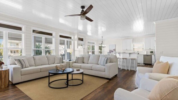 A spacious living room with a large sectional sofa, a coffee table, and a ceiling fan. - Better Together by Brunswick Vacation Rentals: Heated Pool, Great Views & Access (Ocean Isle Beach)
