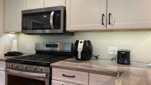 Eine moderne Küche mit Mikrowelle aus Edelstahl, einer Kaffeemaschine und einem Toaster auf der Arbeitsfläche.
