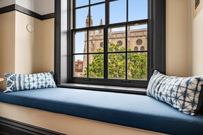 Asiento junto a la ventana con vista a un edificio histórico.