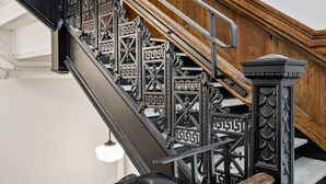 A staircase with ornate black metal railings and wooden steps. - Kasa Quick Walk to Kelly Strayhorn Theater The Maverick (Pittsburgh)