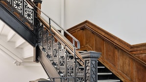 A staircase with ornate black metal railings and wooden steps.