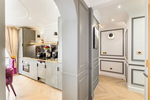 Eine moderne Küche mit Marmorarbeitsplatten, einem eingebauten Backofen und einer Kaffeemaschine.