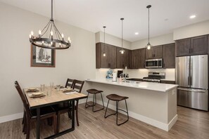 Una cocina moderna con armarios de madera oscura, electrodomésticos de acero inoxidable y una isla central.