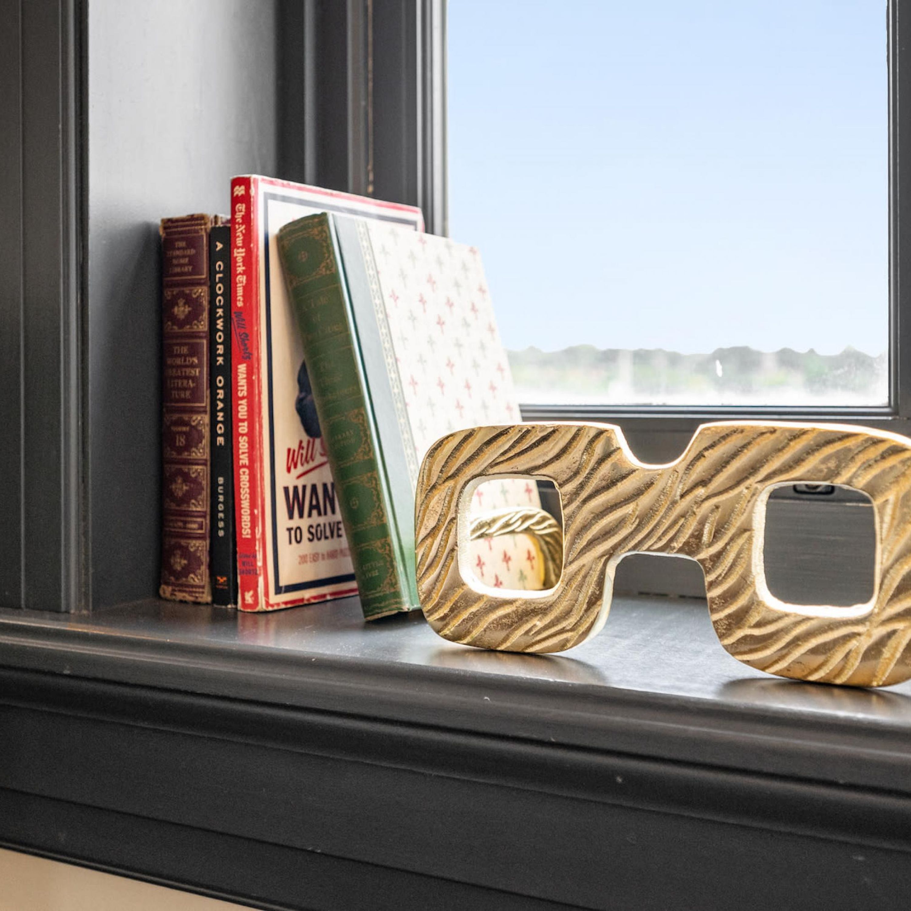 A window sill with books and 3D glasses.
