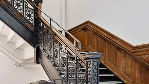 A staircase with ornate black metal railings and wooden steps.