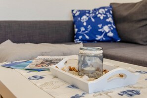 Un bocal en verre contenant une bougie, posé sur un plateau sur une table.