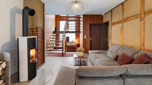 A modern living room with a fireplace, a staircase, and a sofa.