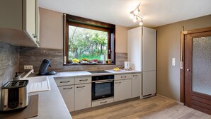 A modern kitchen with a window, built-in oven, and a toaster.
