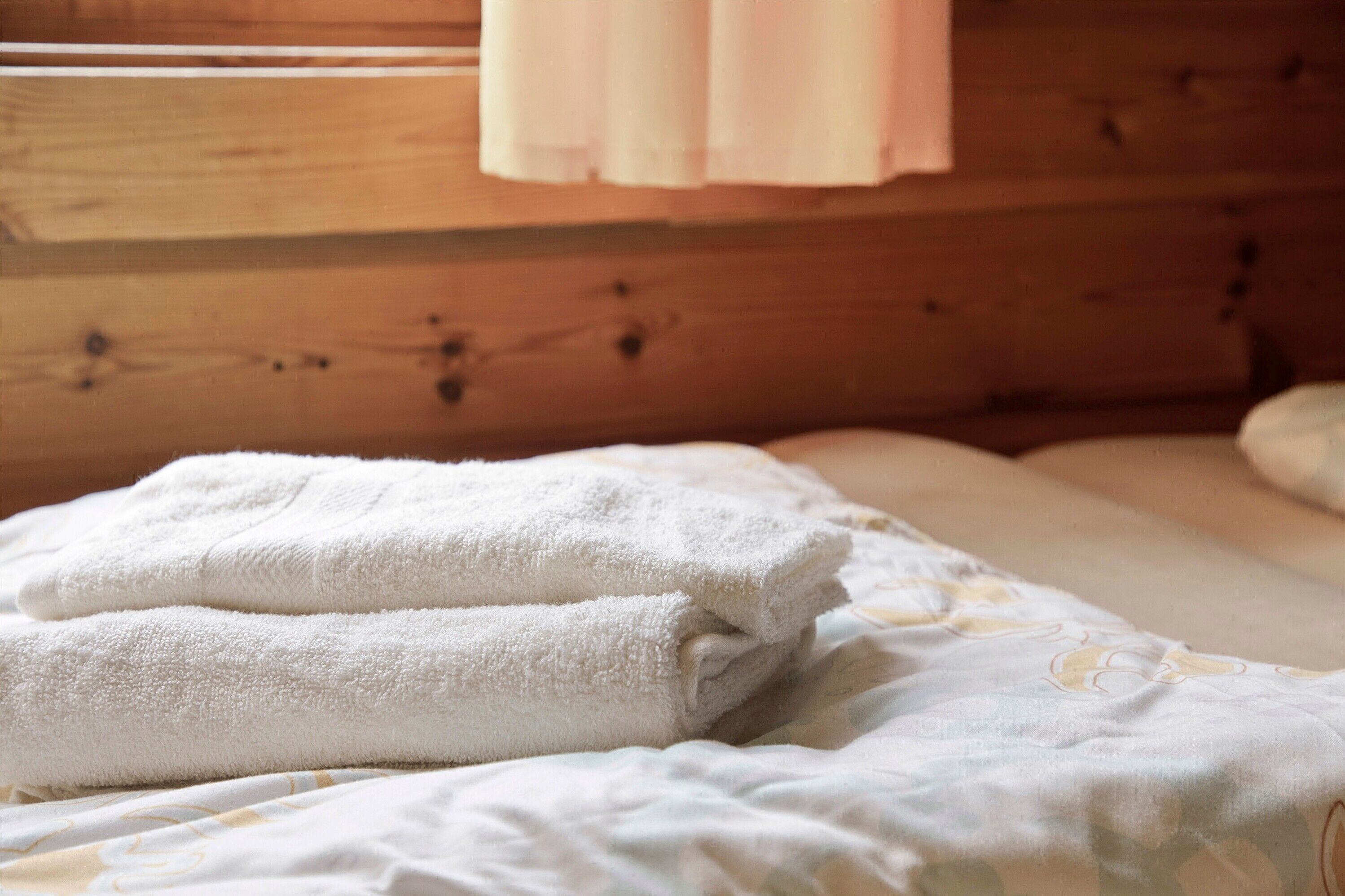 Un lit bien fait, avec des serviettes blanches et une couvre-lit à motifs.