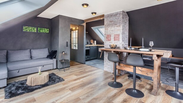 A modern loft with a dining area, kitchen, and living space.