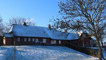 A snow-covered house with a sloped roof and a chimney.