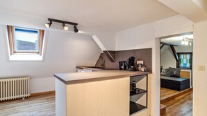 Una cocina moderna con una isla integrada, una ventana y un radiador.