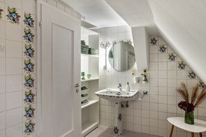 A bathroom with a white tiled wall, a white sink with a mirror, and a white door. - Holiday Apartment "Schwarzwaldtani – Städtle 3" in Bühl (Bühl)