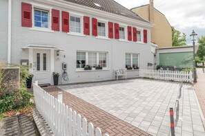 A white building with red shutters, a paved courtyard, and a white picket fence. - Holiday Apartment "Schwarzwaldtani – Städtle 3" in Bühl (Bühl)